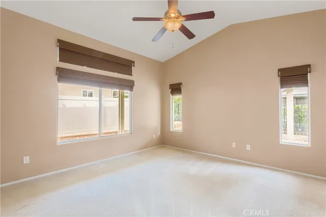 an empty room with windows and fan