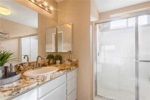 a bathroom with a granite countertop sink and a mirror
