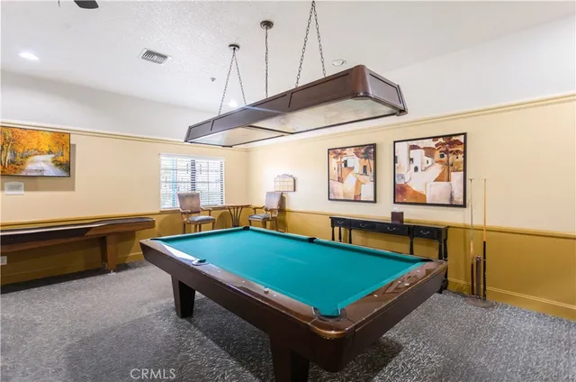 a room with pool table and windows
