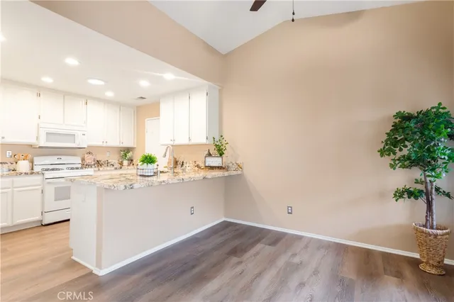 a kitchen with a white stove top oven and white cabinets