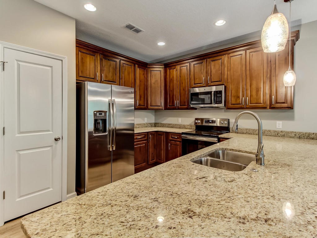 87271 Lents Road Yulee, FL 32097 - Photo 17 of 32 a kitchen with granite countertop a refrigerator stove top oven a sink and dishwasher