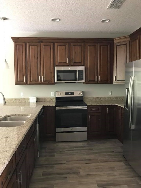 87271 Lents Road Yulee, FL 32097 - Photo 3 of 32 a kitchen with a stove a sink and a microwave
