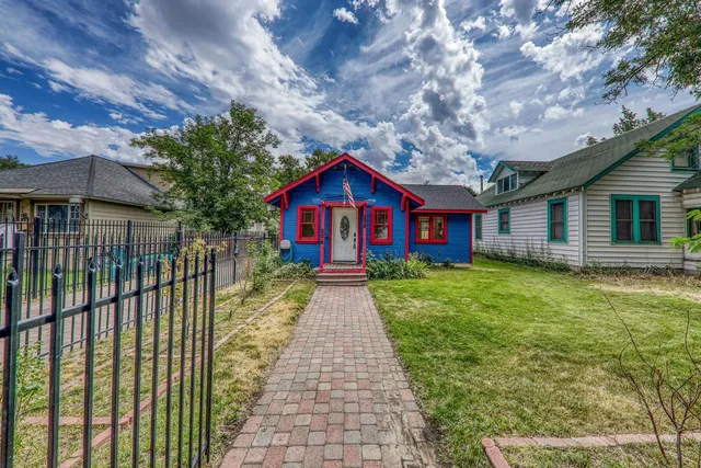 a view of house with a yard and potted plants