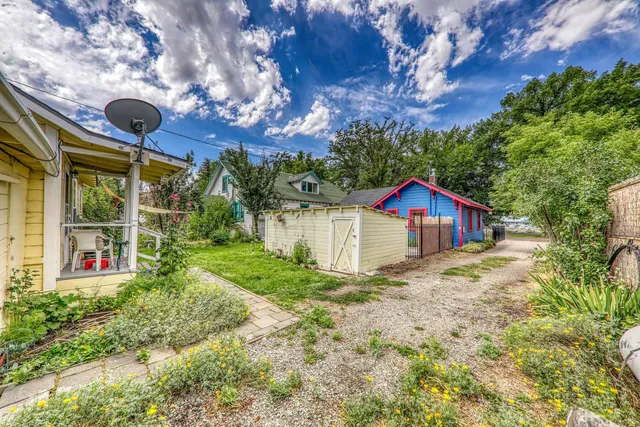 a yellow house with flower garden in front of it
