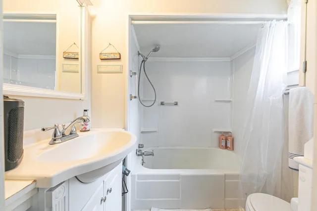 a bathroom with a sink a toilet and shower