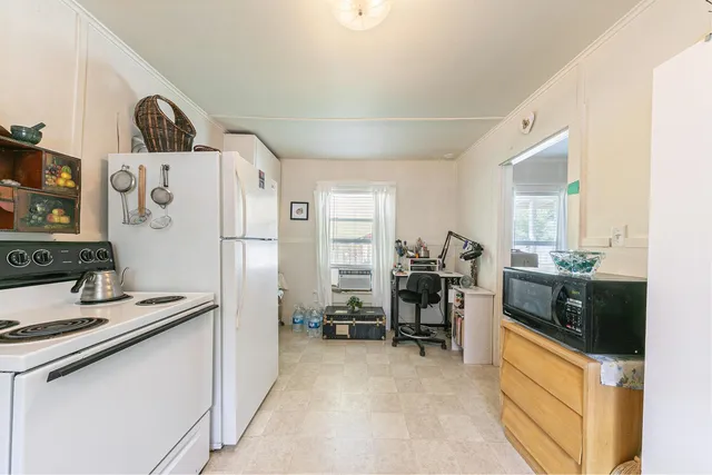 a kitchen with a refrigerator and a stove top oven