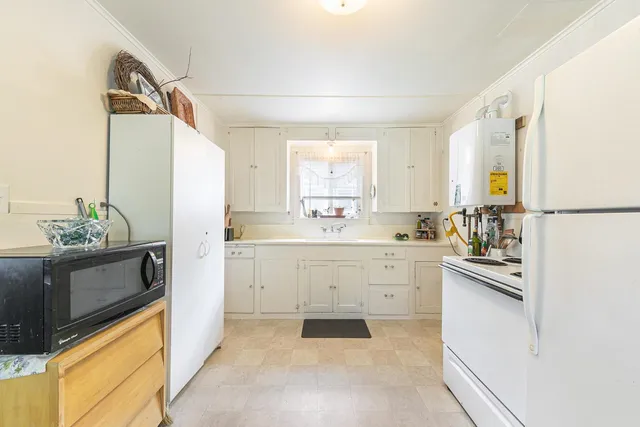 a kitchen with white cabinets and white appliances