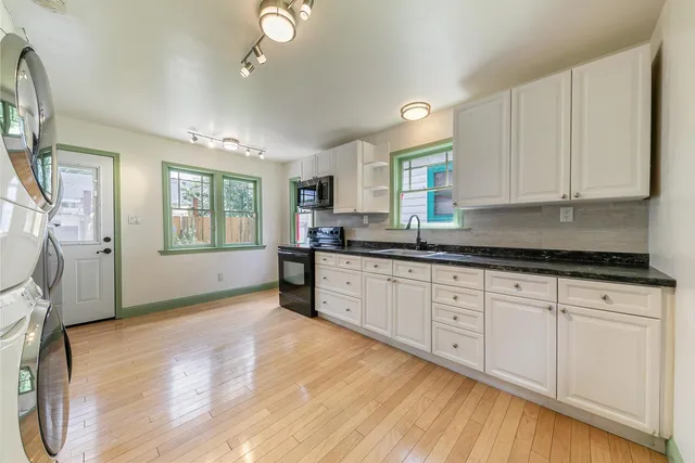 a kitchen with granite countertop white cabinets and white appliances