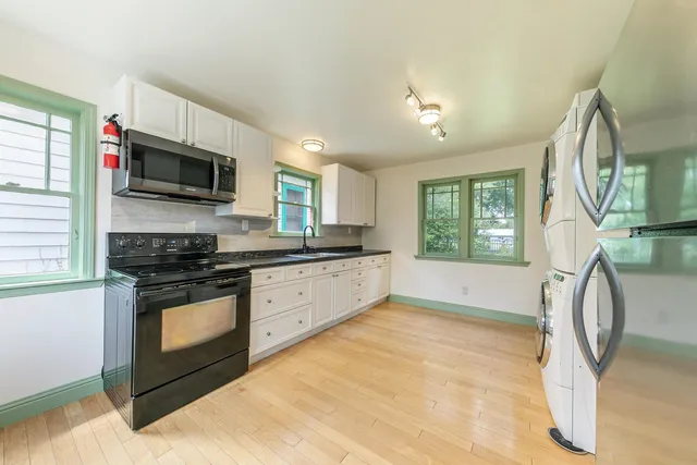 a kitchen with stainless steel appliances granite countertop a stove a sink and a microwave