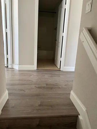 an empty room with wooden floor and a window