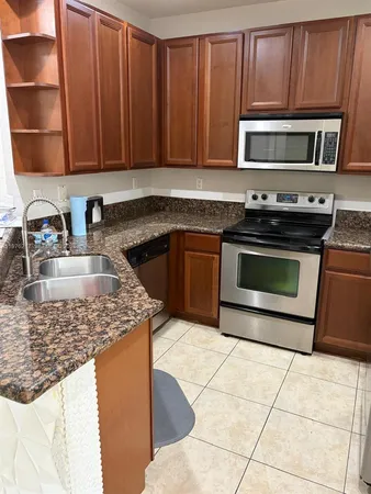 a kitchen with wooden cabinets and a refrigerator
