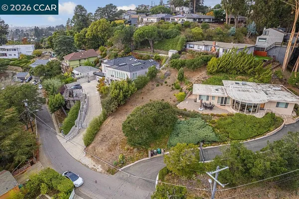 an aerial view of a house with a yard and lake view
