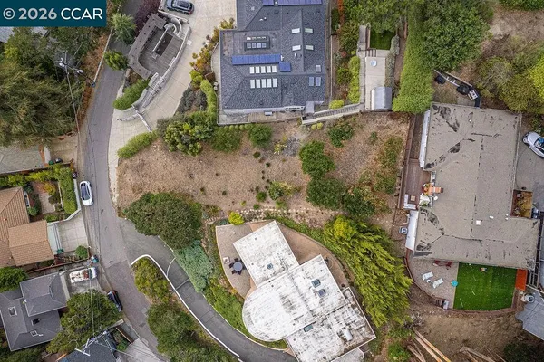 an aerial view of a residential apartment building with a yard and parking spaces