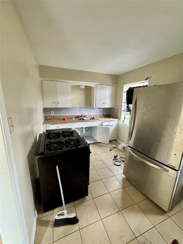 a kitchen with a stove a refrigerator and a sink