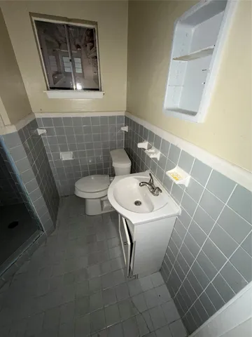 a bathroom with a sink toilet and a mirror
