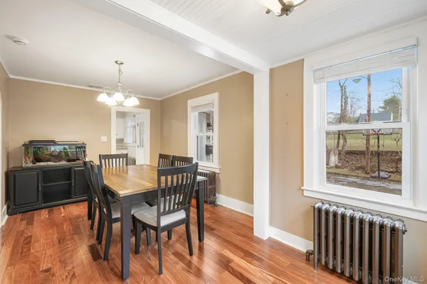 a view of a a dining room with furniture window and wooden floor