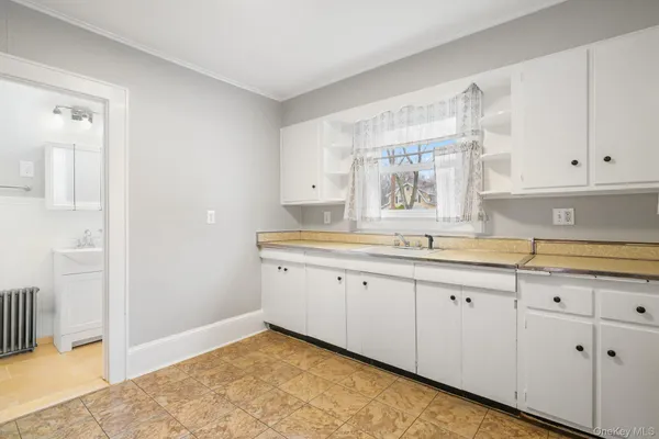 a kitchen with granite countertop white cabinets and a sink