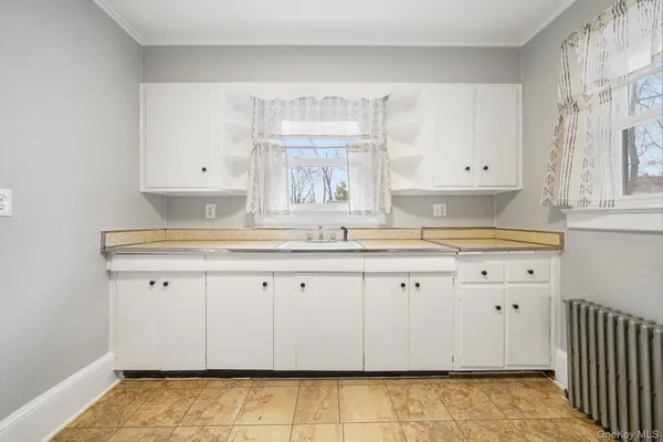a kitchen with granite countertop white cabinets and a sink