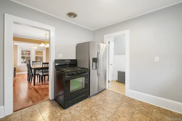 a kitchen with stainless steel appliances granite countertop a stove a refrigerator and a view of living room