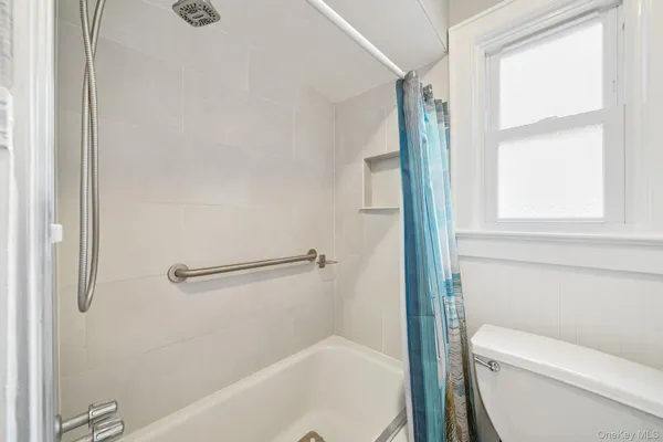 a bathroom with a granite countertop bathtub shower and toilet