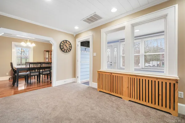 a view of an empty room with window and furniture
