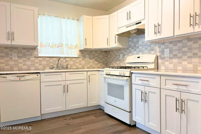 a kitchen with white cabinets and white appliances