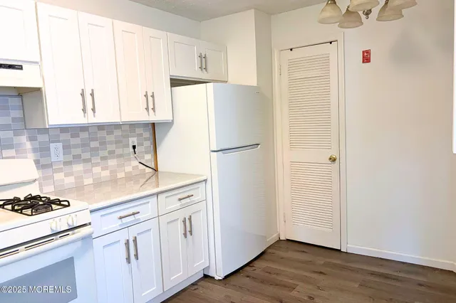 a kitchen with stainless steel appliances white cabinets and a refrigerator
