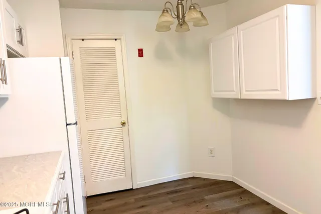 an empty room with wooden floor and cabinet