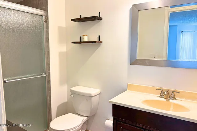 a bathroom with a sink mirror vanity and toilet