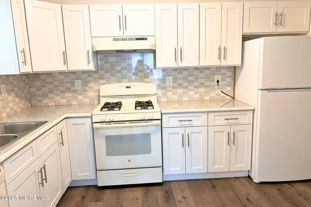 a kitchen with white cabinets and white appliances