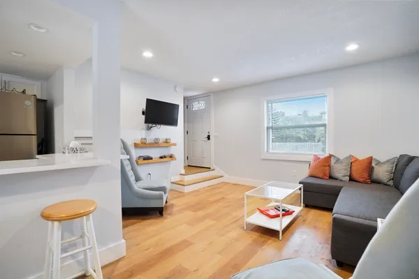 a view of a dining room with furniture a chandelier and wooden floor
