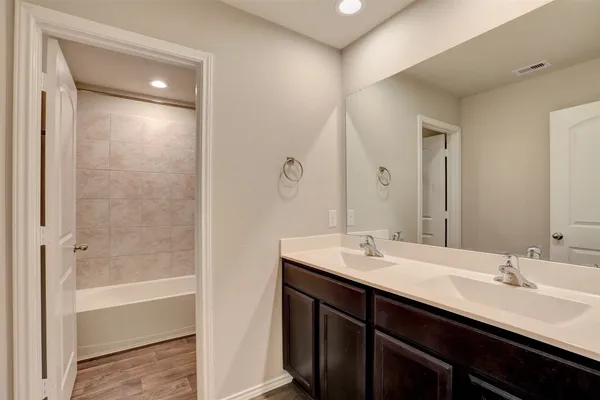 a bathroom with a double vanity sink and a mirror