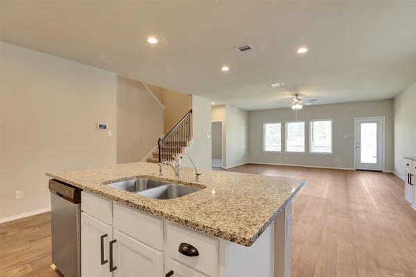 a kitchen with granite countertop a sink stove and refrigerator