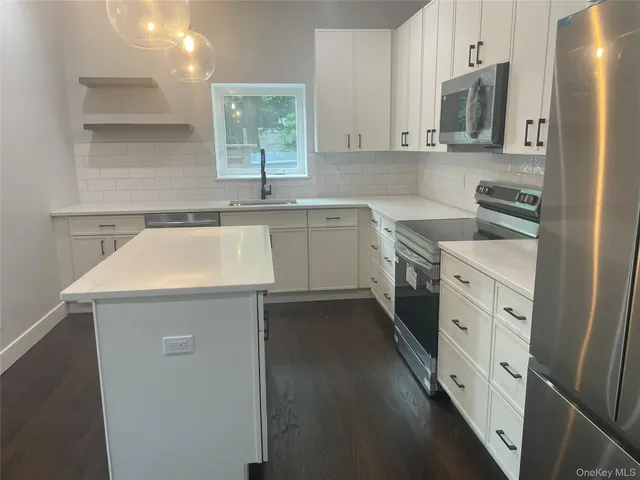 a kitchen with a sink a refrigerator a stove and wooden floor