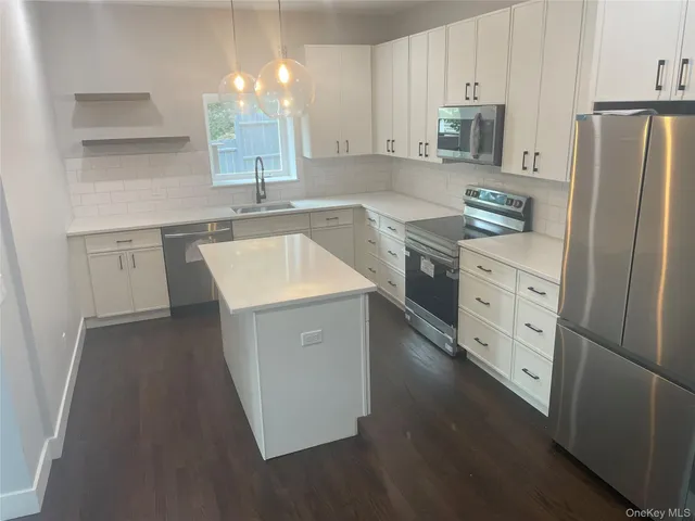 a kitchen with stainless steel appliances a refrigerator sink and cabinets