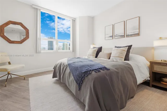 a bedroom with a bed a mirror and a window