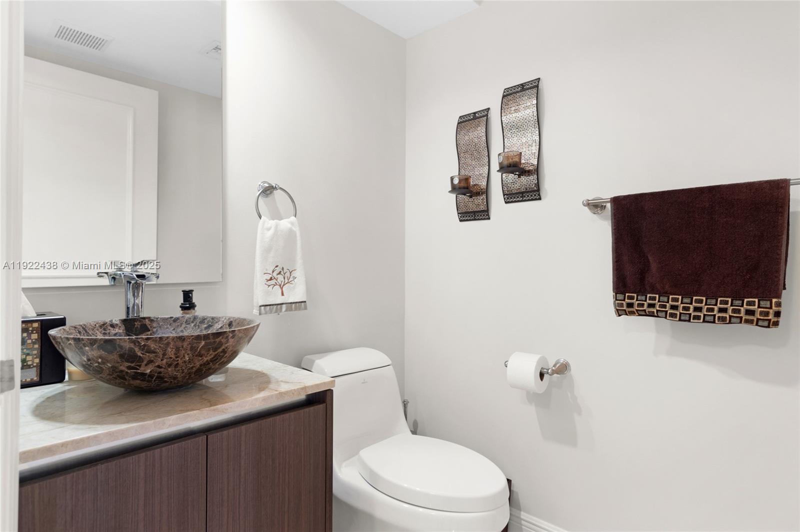 848 Brickell Key Drive, Unit 3905 Miami, FL 33131 - Photo 33 of 47 a bathroom with a toilet sink and mirror