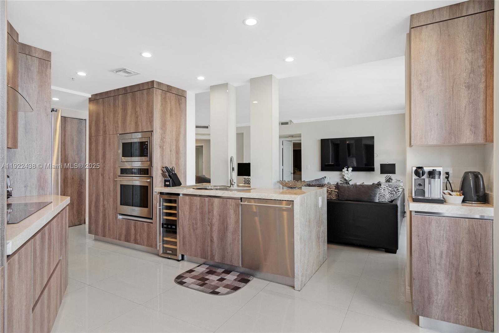 848 Brickell Key Drive, Unit 3905 Miami, FL 33131 - Photo 9 of 47 a view of kitchen with stainless steel appliances kitchen island granite countertop a refrigerator oven a sink dishwasher and white cabinets with wooden floor