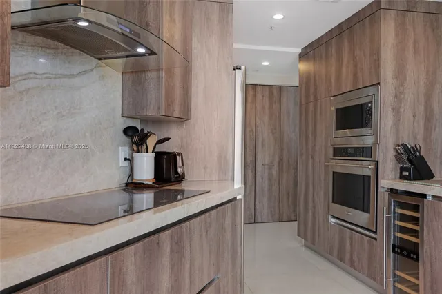 a kitchen with kitchen island a counter top space a sink stainless steel appliances and cabinets