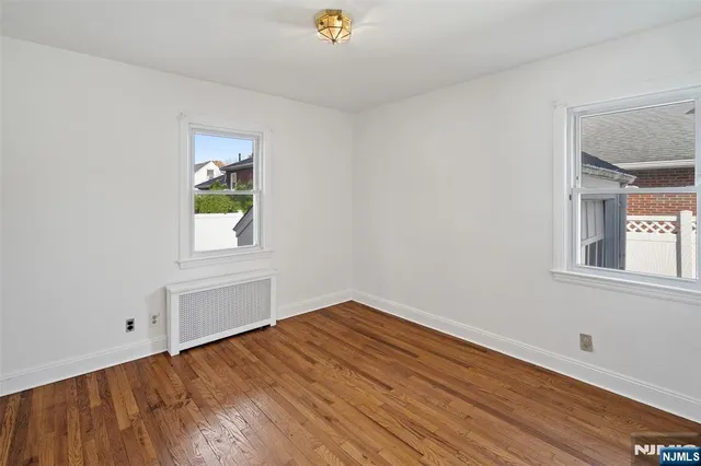 a view of empty room with window and wooden floor