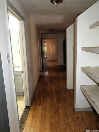 a view of a hallway with wooden floor and staircase