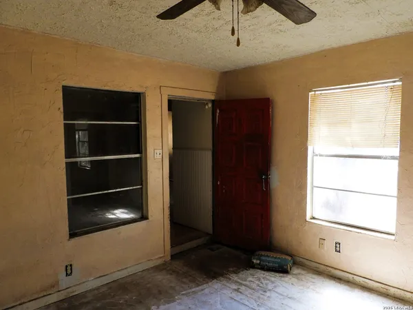 a view of an empty room with a window and a fireplace