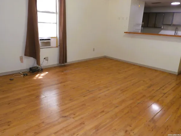 a view of a room with wooden floor and cabinets