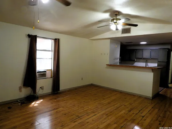 a view of a room with wooden floor and chandelier