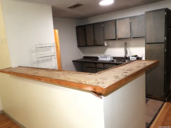 a kitchen with granite countertop a sink a stove and a refrigerator
