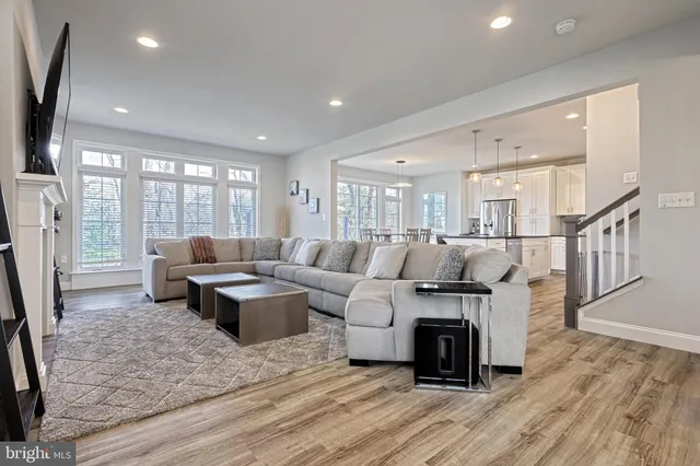 a living room with furniture large window and wooden floor