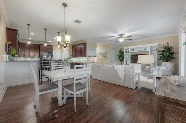 a living room with furniture a dining table and a chandelier
