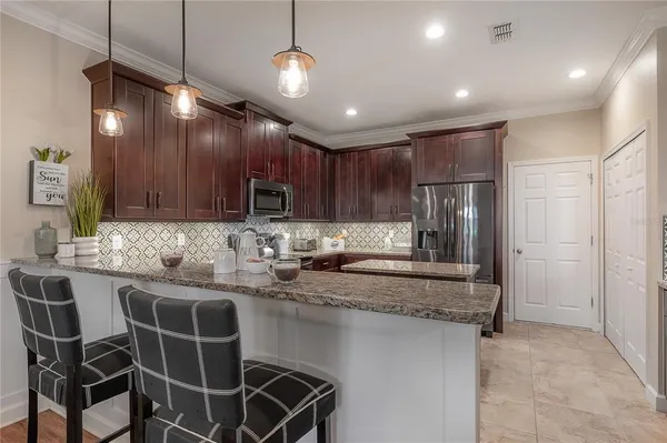 a kitchen with kitchen island granite countertop a sink a center island stainless steel appliances and cabinets
