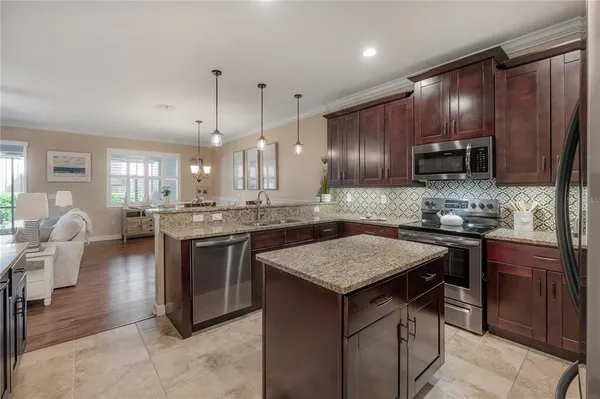 a kitchen with kitchen island granite countertop wooden cabinets and stainless steel appliances