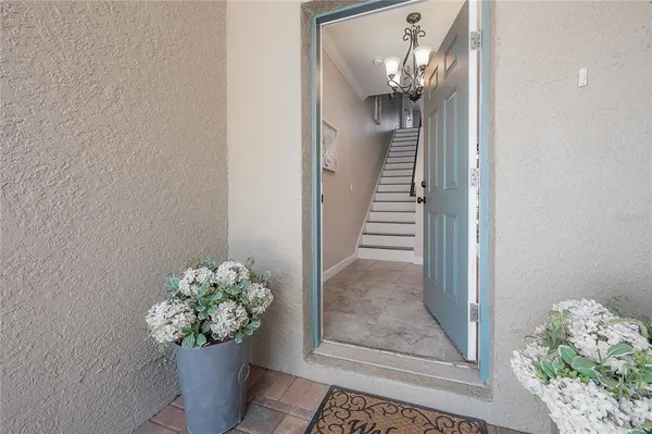 a view of a hallway with wooden floor and a chandelier
